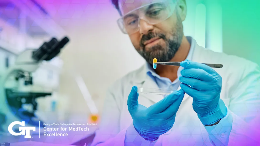 Researcher holding a small pill with tweezers
